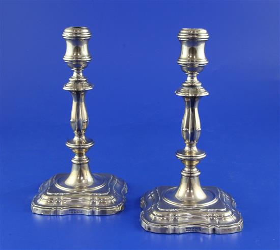 A pair of George V 18th century style silver candlesticks by Mappin & Webb, weighted.